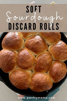 a black pan filled with bread rolls on top of a white tablecloth and text overlay reads soft sourdough discard rolls