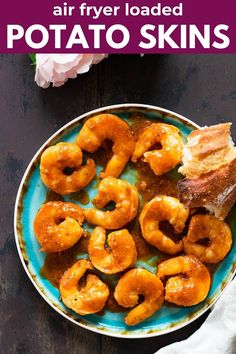 a blue plate topped with fried potato skins and bacon next to a white napkin on top of a wooden table