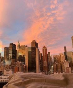 a view of the city skyline at sunset from a rooftop top deck in new york