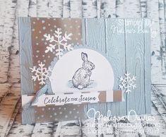 a close up of a card with snowflakes and a rabbit on the front