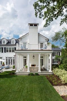 a large white house sitting on top of a lush green field