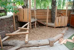 an outdoor play area with wooden structures and trees