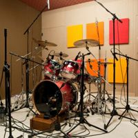 a drum set up with microphones and other musical equipment on the floor in a room