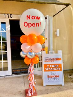 an orange and white balloon with the words now open on it