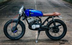 a blue motorcycle parked on top of a parking lot