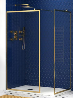 a bathroom with a blue wall and gold trim around the shower head, toilet and bathtub