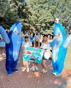 three girls in costumes holding up a sign that says my littles are jaw dropping