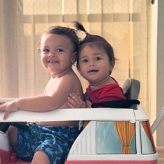 two children sitting on top of a toy vw bus with their arms around each other