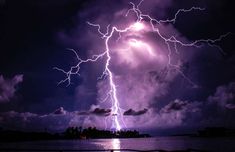 a lightning bolt is seen over the ocean in this artistic photo taken by an unknown photographer