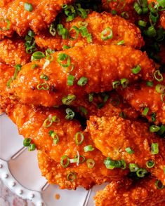 a plate full of fried chicken with green onions