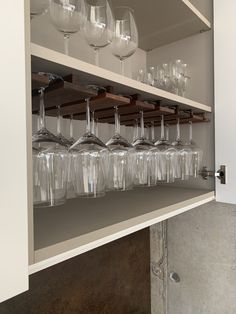 wine glasses are lined up on shelves in a room with no one around them,