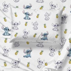 the bedding is made up with cartoon characters on white sheets and pillowcases