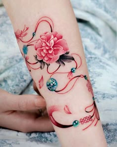 a woman's arm with a flower tattoo on it