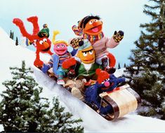 the muppets are riding on a sled in the snow with each other