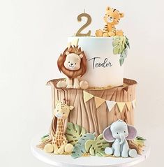 a two tiered jungle themed cake with animals on the top and second tier number