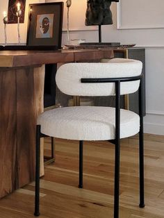 a white chair sitting in front of a desk with a lamp on top of it