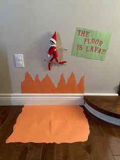 an elf is sitting on the floor in front of a wall with paper cut out