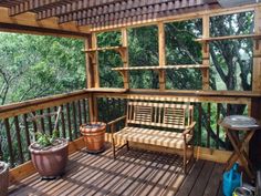 a wooden bench sitting on top of a wooden deck next to a potted plant