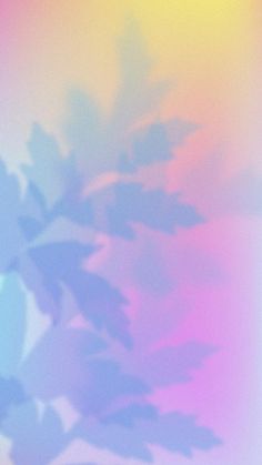 a blurry image of leaves on a pink, blue and green background with the sun shining through them