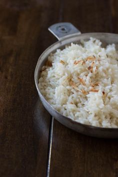 white rice in a pan on a wooden table