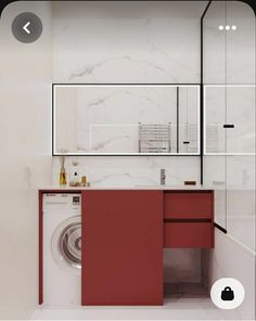 a washer and dryer in a white bathroom with red cabinetry on the wall