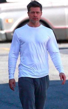 a man in white shirt walking down the street