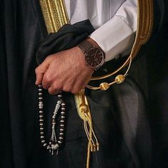 a close up of a person wearing some beads and a watch on his arm with other bracelets