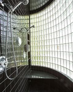 a bathroom with black and white tiles on the walls, shower head and hand held faucet