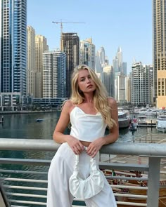 a woman is posing for a photo in front of the city