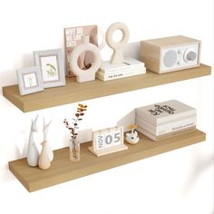 two wooden shelves with books, vases and pictures on them