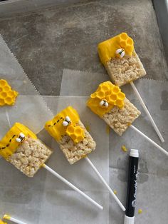 rice krispy treats with yellow frosting and honeycombs on them, sitting on wax paper