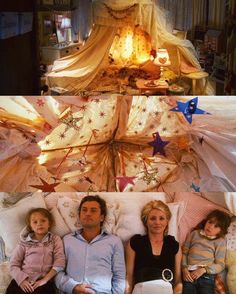 a group of people sitting on top of a bed next to each other in front of a christmas tree