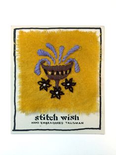 a yellow cloth with black flowers on it and the words stitch wish written in white