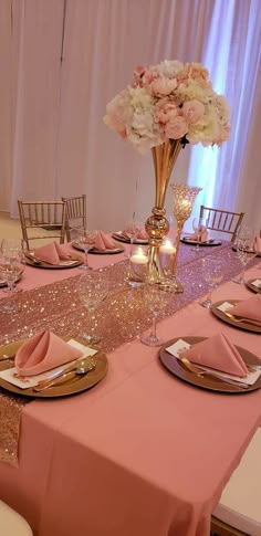 the table is set with pink and gold place settings