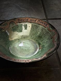 a green bowl sitting on top of a tile floor