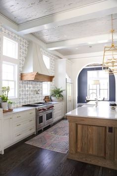 a kitchen with an island, stove and oven in it's center area is shown