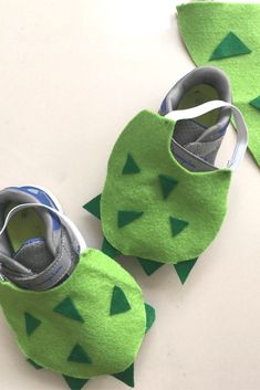 two baby shoes made out of felt with green and blue designs on the soles