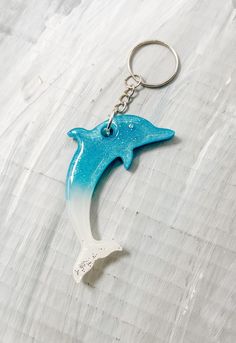 Glow in the Dark! Blue white Dolphin Keychain! Handmade by me! Resin Key Chain Approximately 2.5 inches long, Stainless Steel Key Ring, Resin Material I love making resin gifts! Some of my favorite projects are working with resin! Each piece is so unique, never the same pour twice. These Keychains are super cute. A must have for anyone who enjoys dolphins.  Thank you for looking. Please make sure to favorite my store so you won't miss any sales or updates.  Lisa PS Each piece is unique, and are perfectly charming. With Resin there can  be minor imperfections. Shipping INFO Canada:  Free Shipping =Standard shipping no tracking available=Stamps are used and Canada Post will deliver within approximately 3-8 business days. For Canada: If tracking or quicker shipment is needed, please upgrade s Dolphin Keychain, Resin Gifts, White Dolphin, Dolphin Gifts, Keychain Resin, Clay Inspo, Ring Resin, Blue Dolphin, Resin Keychain