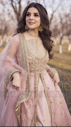 a woman in a pink dress posing for the camera