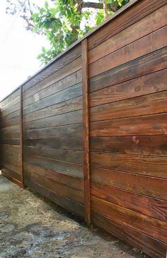 a large wooden fence next to a tree