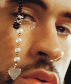 a close up of a man with piercings on his nose and nose chain attached to his nose