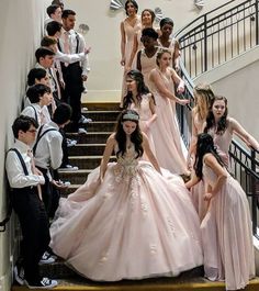 a group of young people dressed in formal wear standing on the stairs next to each other