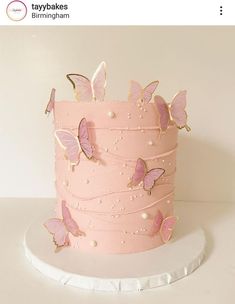 there is a pink cake with butterflies on it