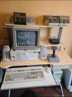 an old computer sitting on top of a desk next to a keyboard and monitor,