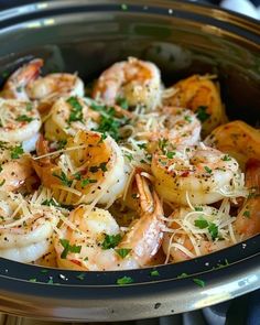 cooked shrimp with parmesan cheese and herbs in a slow cooker