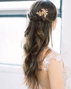 the back of a woman's head wearing a gold hair comb