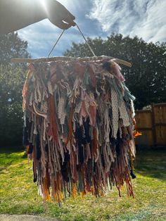 a person is holding up a piece of cloth hanging from a clothes line in the yard