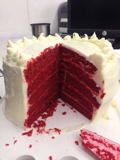 a large red velvet cake with white frosting