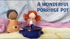 two dolls sitting on top of a bed next to a pot with water in it