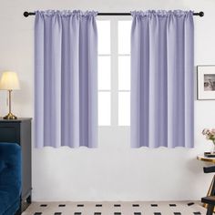 a living room with blue furniture and curtains